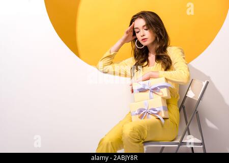 Belle femme à la recherche de cadeaux sur l'orange et blanc Banque D'Images