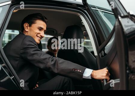 Smiling businessman la fermeture de porte passager taxi Banque D'Images