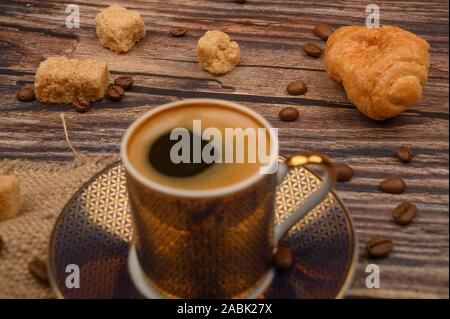 Tasse à café, croissants, le sucre brun et les grains de café sur fond de bois. Close up Banque D'Images