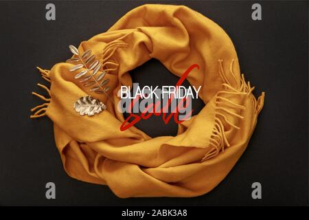 Vue de dessus de l'écharpe confortable jaune sur fond noir avec le black friday vente illustration Banque D'Images