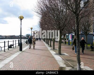 Les gens qui marchent sur le trottoir le long du bassin de l'Ontario, Manchester Ship Canal, les quais, Salford, Manchester, Angleterre, RU Banque D'Images