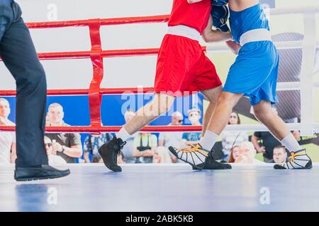 Deux boxeurs combats dans le ring de boxe, vue sur les jambes. Image horizontale. Banque D'Images