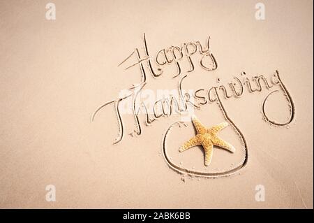 Message calligraphie joyeux Thanksgiving à la main sur la plage avec sable lisse avec étoile de copy space Banque D'Images