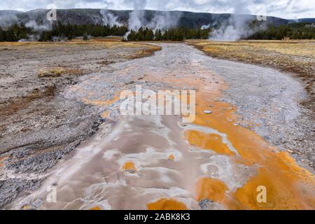 L'eau bouillante de la chaleur géothermique de geyser basin s'écoule autour de la zone orange et d'autres couleurs en raison de niveau de température et le type de bactéries Banque D'Images