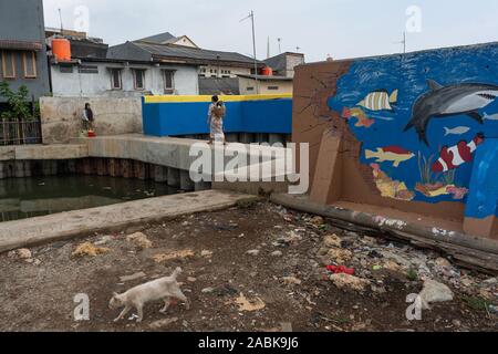 Au nord de Jakarta, Indonésie. 18 Oct, 2019. Les gens marchent dans le Kampung Aquarium, au nord de Jakarta, Indonésie, près d'un mur de protection. (Dpa : 'la mer, le mur et le pouvoir de détruire la nature") Credit : Fauzan Ijazah/dpa/Alamy Live News Banque D'Images