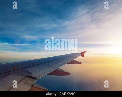 Ciel coucher de soleil vu à travers de la fenêtre, la fenêtre de l'avion avion Voyages et vacances. Banque D'Images