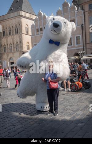 Un musicien ambulant vêtu comme un énorme ours polaire pose pour des photos avec touriste qui il demandera à un don. Dans la vieille ville de Prague, République tchèque. Banque D'Images