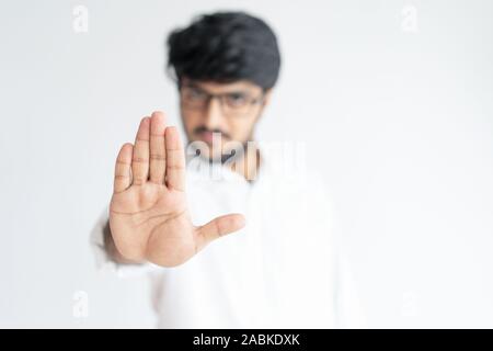 L'homme Indien floue montrant ouvrez Palm ou cesser de geste. De strictes et de nier quelque chose. Concept de déni. Vue avant isolé sur fond blanc Banque D'Images