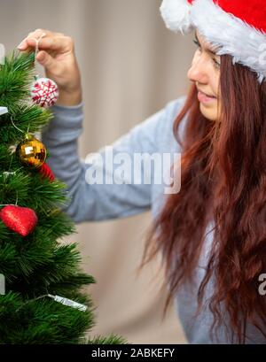 Femme décore Nouvel An des arbres de Noël avec jouet en après-midi Banque D'Images