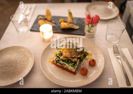 Piasame Lavraki - Boucle de Mer du grill pierre de lave aux épinards risotto et tomates cerises caramélisées, raffiné avec orange-sauce à la lime, dans le restaurant grec Apla 'funky''à Buttermelcherstraße 21 dans la Gärtnerplatz trimestre. [Traduction automatique] Banque D'Images