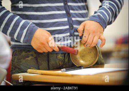 Conception sonore expérimental sur le calendrier dans l'école secondaire sur Wittelsbacherstraße. Le projet en KLANGRADAR les élèves apprennent à prêter attention aux sons et bruits et de les créer eux-mêmes sur différents instruments (ici : un bol chantant). [Traduction automatique] Banque D'Images