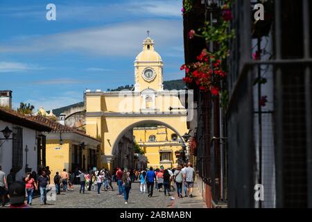 Les gens qui marchent dans la rue principale de Antigua Guatemala avec l'arc de Santa Catalina derrière Banque D'Images