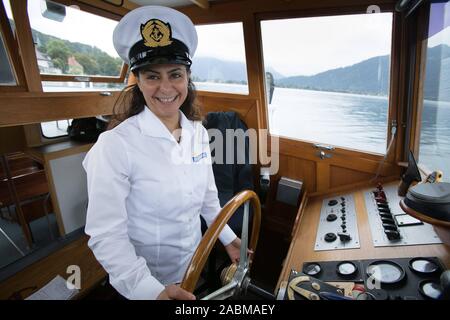 Le capitaine syrien Najd Boshi steers le ferry sur le Tegernsee. [Traduction automatique] Banque D'Images