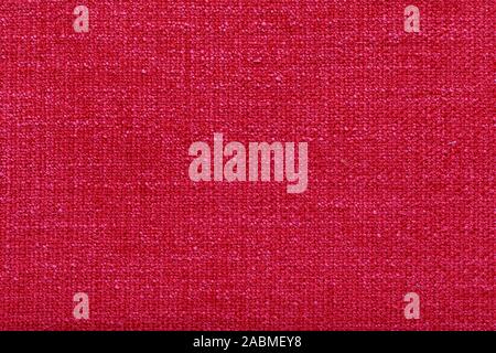 Fibre polyester texture rouge corail de près. La structure tissulaire libre. fine grain estimé tissu rouge. Fond en tissu. Banque D'Images