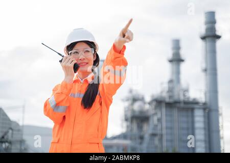 Femme d'origine asiatique avec un ingénieur radio fonctionne à l'extérieur de l'usine. Banque D'Images