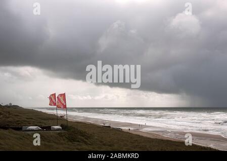 Blick von den Dünen auf Strand und Meer unter tiefhängenden Regenwolken Banque D'Images
