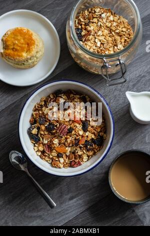 Céréales Granola aux fruits bol à petit déjeuner avec lait sur fond en bois Banque D'Images