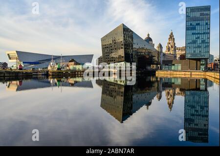 Immeubles de bureaux modernes et le Liver Building avec leurs reflets dans l'eau d'un bleu profond de Canning Dock sur une journée ensoleillée. Banque D'Images