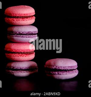Macarons sur fond sombre, colorée cookies macarons français. Macarons Banque D'Images