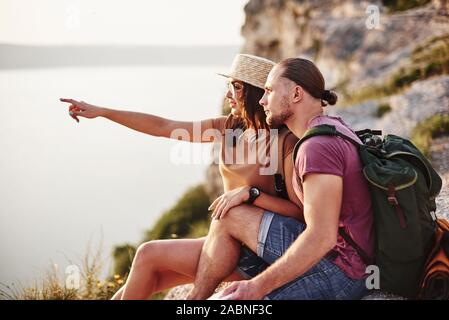 J'ai vu quelque chose, n'avez-vous pas voir la même chose. Jeune couple reposant de marcher au bord de la montagne. Se demande dans quelle mesure est-il de la côte d'autres Banque D'Images