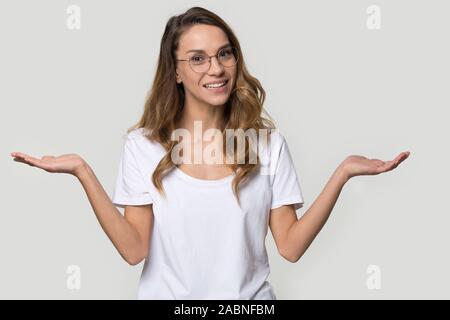 Confondre jeune femme portant des lunettes en haussant les épaules Banque D'Images