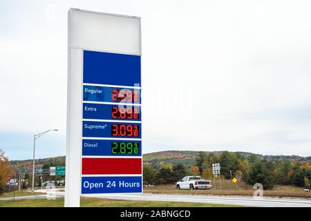 Station essence signer avec des prix le long d'une autoroute sur un jour d'automne nuageux Banque D'Images