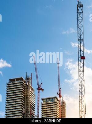 Deux grandes tours de bureaux en construction avec trois grandes grues sur un jour clair au lever du soleil, Londres, Angleterre Banque D'Images