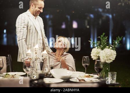 Beau couple a répondre à l'extérieur lieu de restaurant à temps le soir Banque D'Images