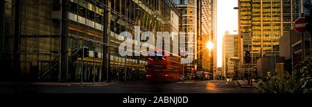 Après une panoramique high street, dans le centre de Londres avec véhicules brouillée, avec un soleil bas sur la capture d'une façade en verre moderne sky scrapers. L'Angleterre Banque D'Images