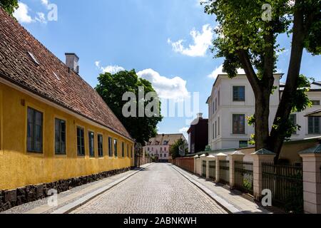 Lund, Suède - le 24 juin 2018 : Une vieille maison jaune à côté de travers une rue pavée dans le centre-ville de Lund, ville universitaire Banque D'Images