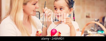 Maison de vacances de Pâques, la famille, l'enfant et de concept - petite fille et mère d'oeufs de pâques à colorier Banque D'Images