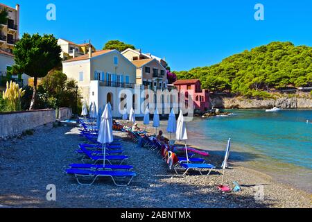 Une vue de la plage de galets dans le beau village de pêcheurs d'Assos.maisons colorées sur le flanc de remplir ce qu'est un parfait lieu de vacances. Banque D'Images