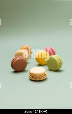 Plus de macarons savoureux de couleur un fond vert. Banque D'Images