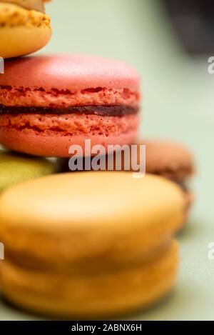 Plus de macarons savoureux de couleur un fond vert. Banque D'Images