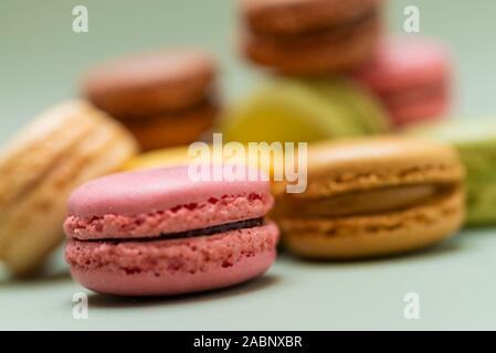 Plus de macarons savoureux de couleur un fond vert. Banque D'Images