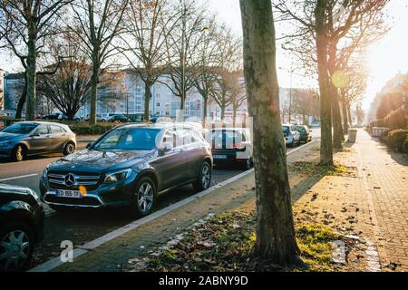 Strasbourg, France - Dec 19, 2016 : Matin rue vide en France avec Mercedes-Benz SUV, VW Golf et d'autres voitures garées cinematic flare Banque D'Images