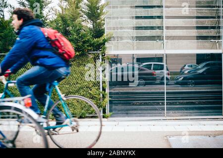 Strasbourg, France - Dec 21, 2016 : Vue de côté de l'homme fast motion sur la bicyclette et la réflexion des voitures en attente dans traffic jam Banque D'Images