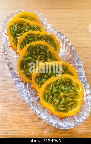 Tranches de melon kiwano dans du verre plat de service Banque D'Images