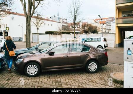 Kehl, Allemagne - 13 déc 2016 : Woman walking in Skoda Octavia voiture garée sur la rue allemande Banque D'Images