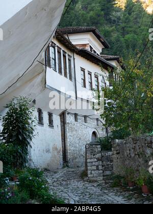 Berat, Albanie - 27 septembre 2019 : maison ottomane avec plusieurs fenêtres construit sur une colline à Berat, en Albanie avec un sentier pavées lin Banque D'Images