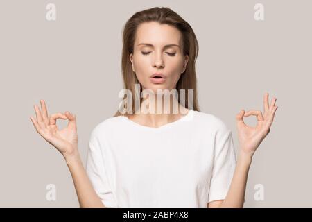 Femme calme relaxant, pratiquant le yoga, méditer avec les yeux fermés Banque D'Images