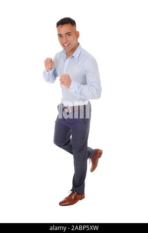 Un beau jeune homme en chemise bleue et pantalon de ville est en cours d'exécution dans le studio, isolée pour fond blanc Banque D'Images