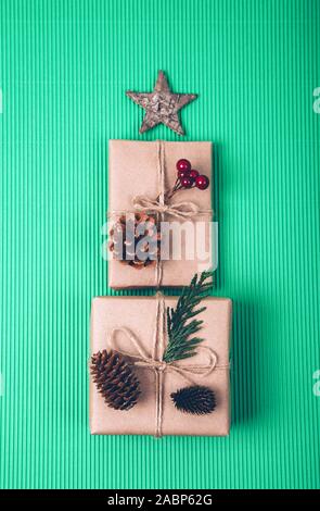 Cadeaux de Noël Décoration avec énoncés dans la forme d'un arbre de Noël sur fond vert, vue de dessus. Banque D'Images
