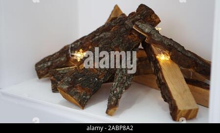 Pile de bois de chauffage et de la guirlande sur fond clair, plan rapproché sur white Banque D'Images