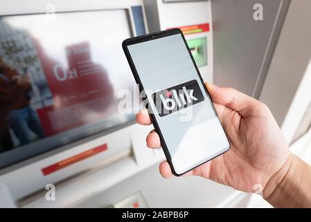 Wroclaw, Pologne - NOV 06, 2019 : Man holding smartphone avec logo Blik et de retrait de l'argent dans un distributeur. Blik est plus populaires polonais rencontré paiement rapide Banque D'Images