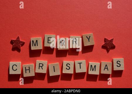 Joyeux Noël en 3D wooden alphabet lettres avec glitter rouge sur un fond rouge avec copie espace Banque D'Images
