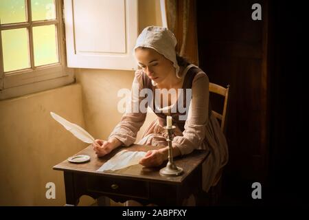 Style Vermeer portrait d'une jeune femme en costume renaissance écrit une lettre avec une plume quill Banque D'Images