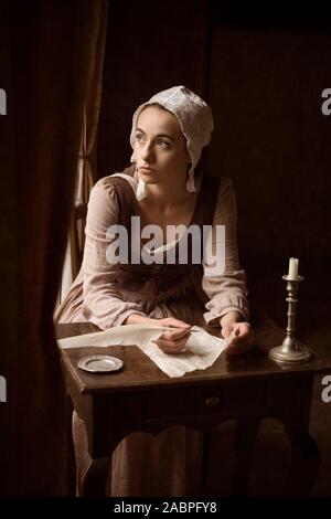 Style Vermeer portrait d'une jeune femme en costume renaissance écrit une lettre avec une plume quill Banque D'Images
