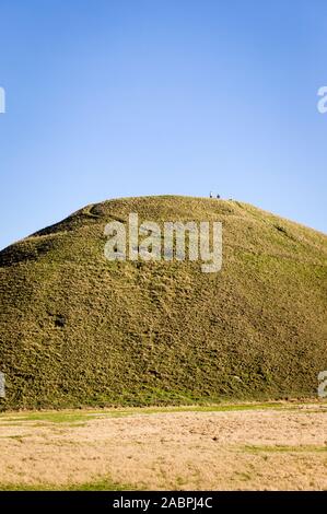 Les chiffres d'un petit homme femme et chien en haut de Silbury Hill un monument ancien près de Marlborough Wiltshire England UK Banque D'Images