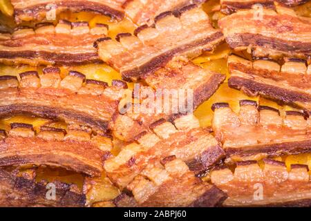 Crisp bacon cuit dans une pile. Photo en gros plan de bacon frit étant dans une casserole. Banque D'Images